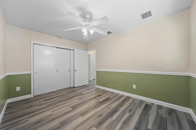 unfurnished bedroom featuring wood-type flooring, ceiling fan, and a closet