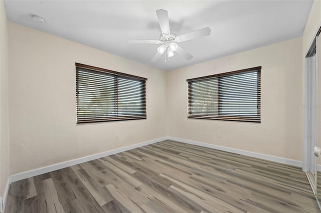 unfurnished room featuring hardwood / wood-style flooring, a healthy amount of sunlight, and ceiling fan