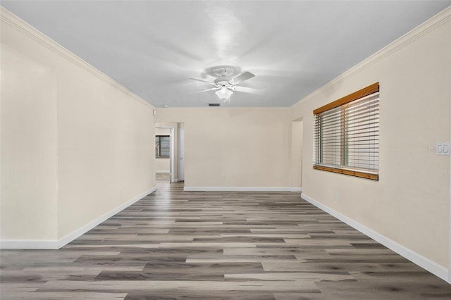 empty room with hardwood / wood-style flooring, ornamental molding, and ceiling fan