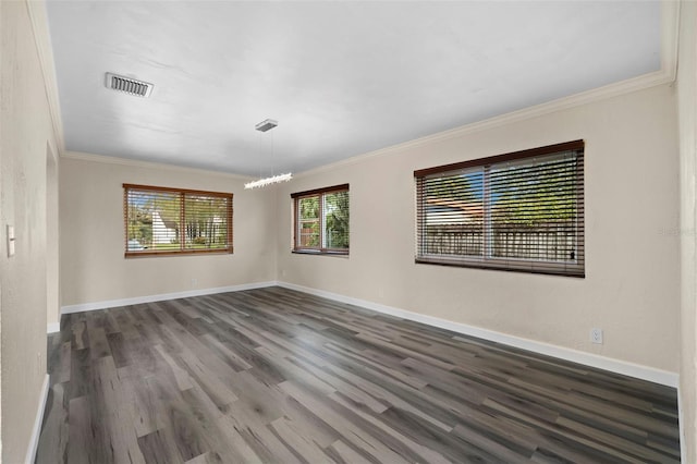 spare room featuring crown molding and dark hardwood / wood-style floors