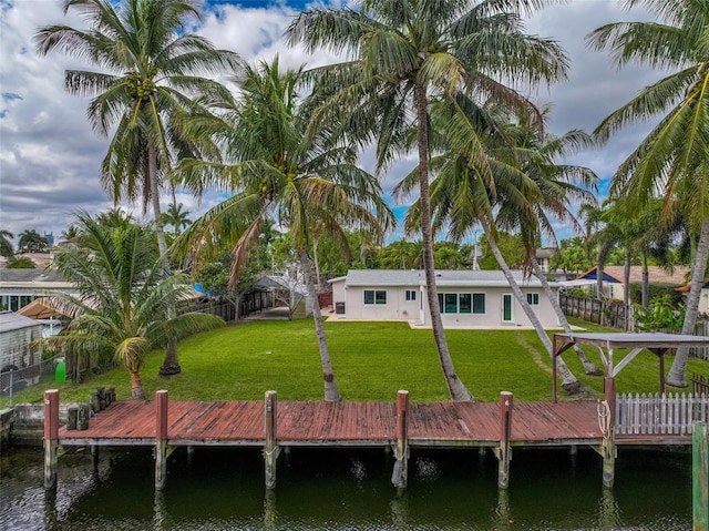 rear view of property featuring a water view and a yard