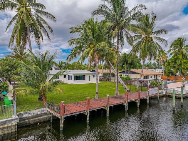 view of dock with a yard and a water view