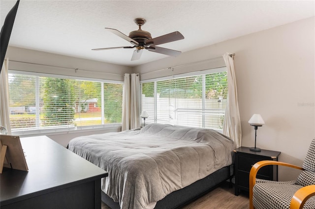 bedroom with ceiling fan, hardwood / wood-style flooring, and a textured ceiling