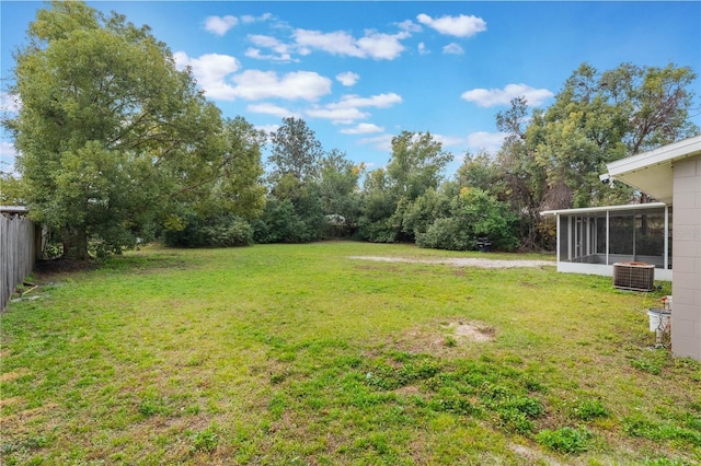 view of yard featuring central AC unit and a sunroom