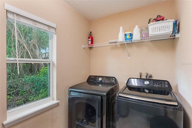 laundry area with washing machine and clothes dryer and plenty of natural light