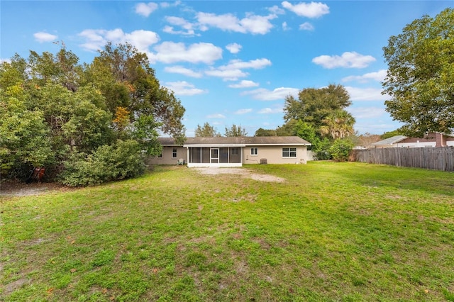 back of property with a sunroom and a yard