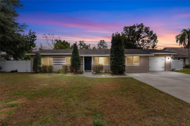 single story home with a garage and a lawn