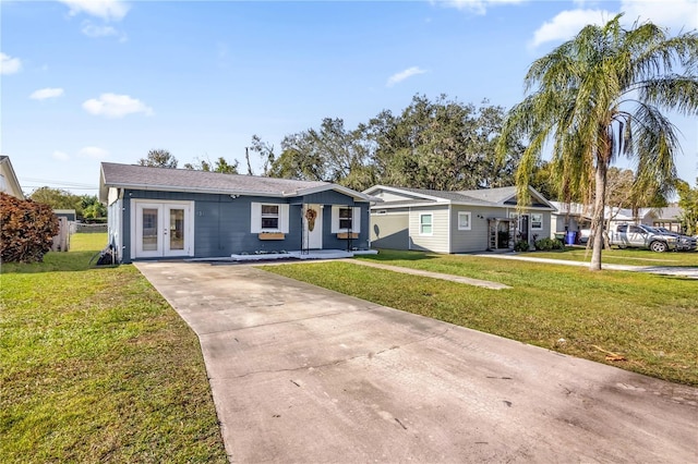 ranch-style home with a front lawn and french doors