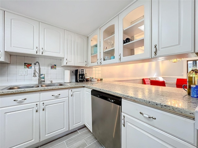 kitchen with dishwasher, sink, white cabinets, and decorative backsplash