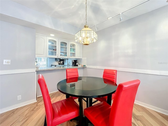 dining space featuring rail lighting and light hardwood / wood-style floors