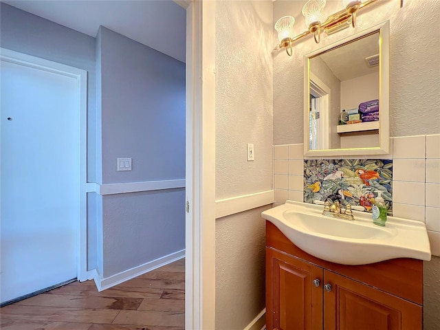 bathroom with vanity, wood-type flooring, and backsplash