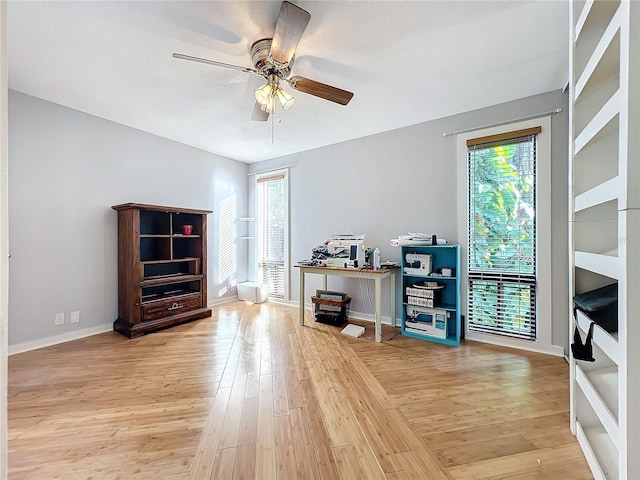 misc room with ceiling fan and light wood-type flooring