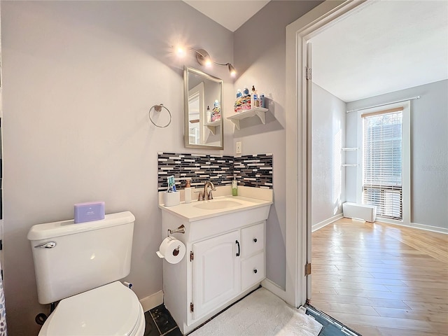 bathroom with tasteful backsplash, vanity, wood-type flooring, and toilet