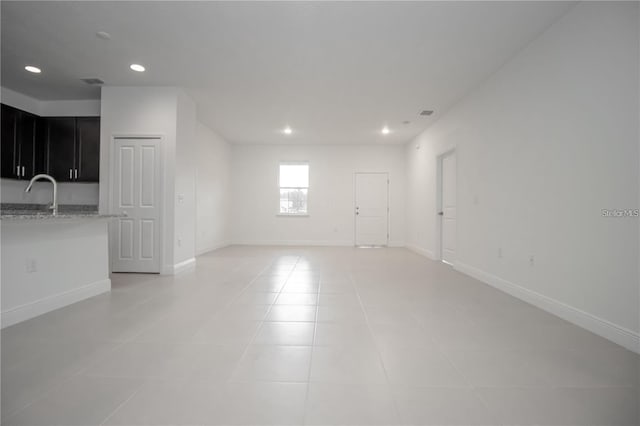 unfurnished room featuring sink and light tile patterned flooring