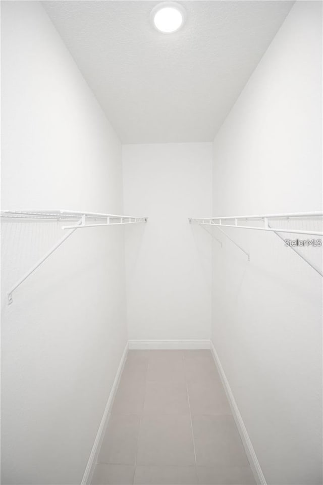 walk in closet with light tile patterned floors