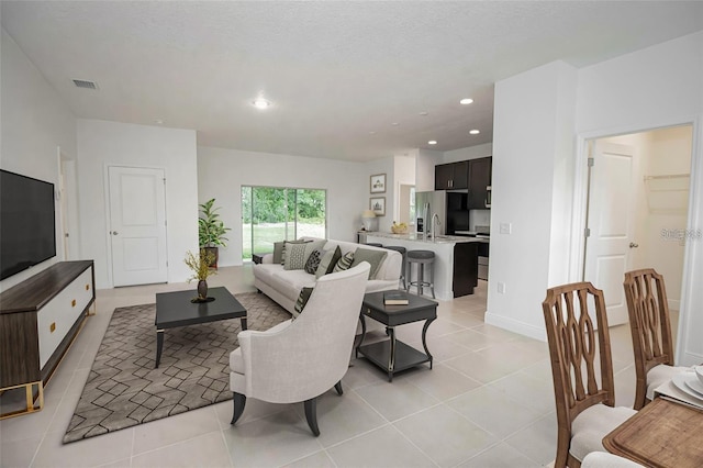 living area with recessed lighting, visible vents, and light tile patterned floors