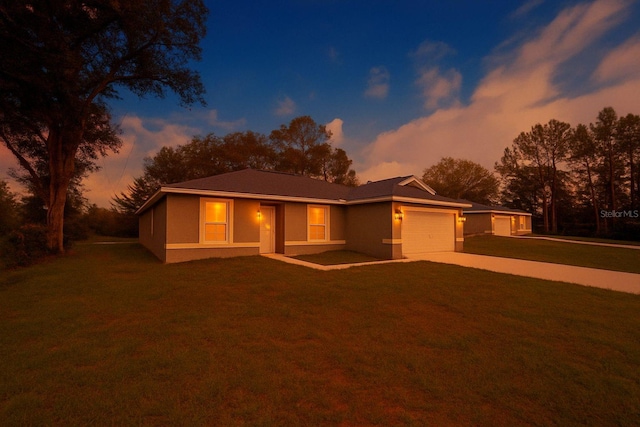 view of front of home featuring a garage, a lawn, and concrete driveway