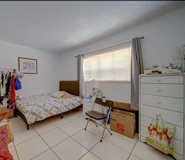 bedroom featuring light tile patterned flooring and a textured ceiling