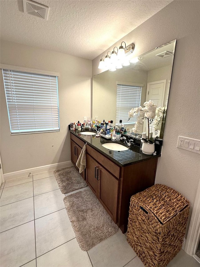 bathroom with tile patterned flooring, vanity, and a textured ceiling