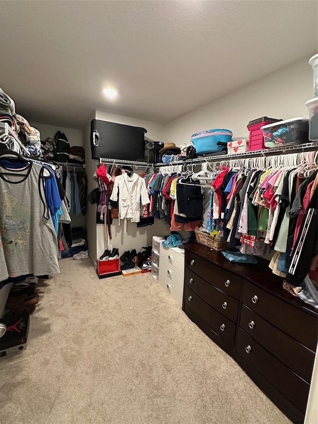 walk in closet featuring light colored carpet