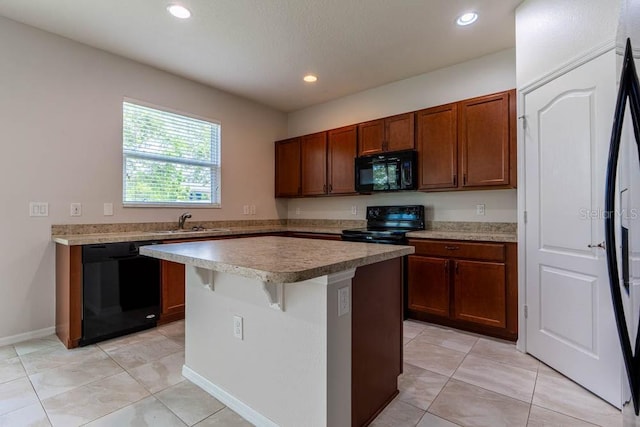 kitchen featuring light tile patterned flooring, sink, a breakfast bar area, a center island, and black appliances