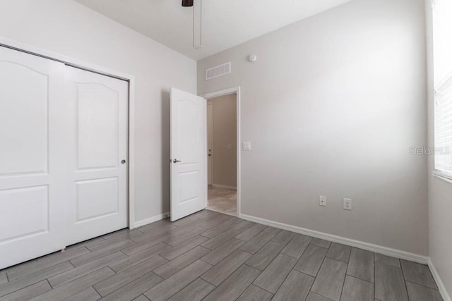 unfurnished bedroom featuring ceiling fan and a closet