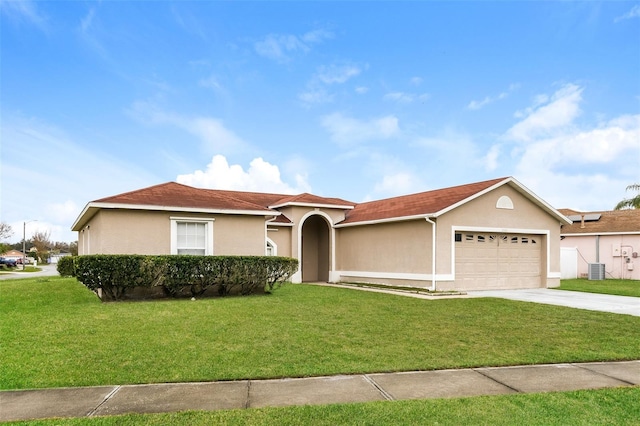 view of front of home with a garage, central AC, and a front lawn