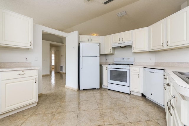 kitchen featuring lofted ceiling, light tile patterned floors, white appliances, and white cabinets