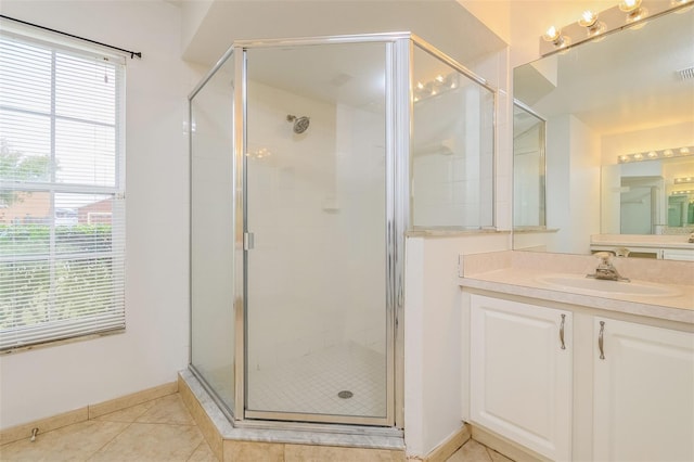 bathroom featuring tile patterned flooring, vanity, and a shower with door