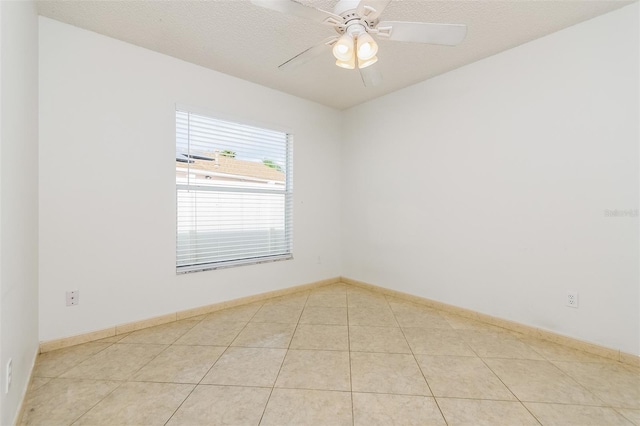 spare room featuring light tile patterned floors, a textured ceiling, and ceiling fan