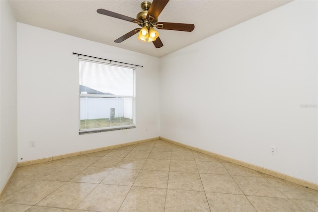 empty room with light tile patterned floors, a textured ceiling, and ceiling fan