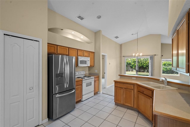 kitchen featuring light tile patterned flooring, pendant lighting, lofted ceiling, sink, and white appliances