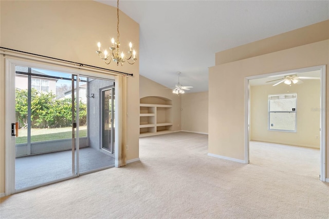 carpeted empty room with built in shelves, vaulted ceiling, and ceiling fan with notable chandelier