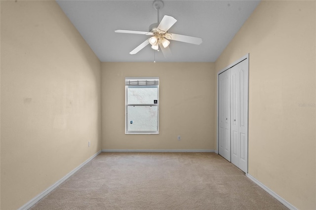 unfurnished bedroom featuring ceiling fan, a closet, and light carpet