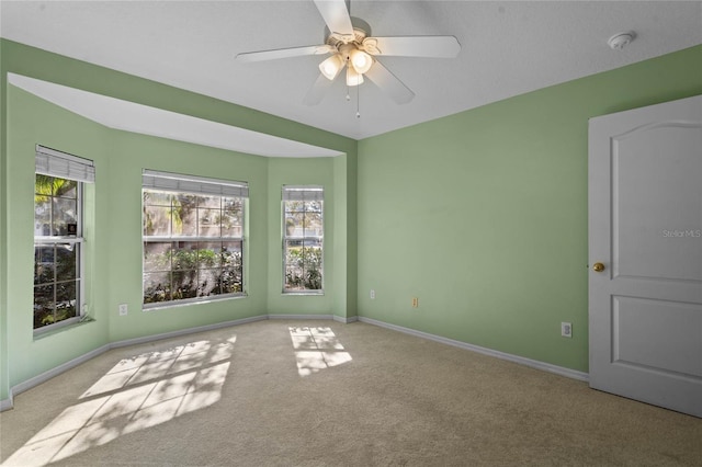 spare room with ceiling fan and light colored carpet