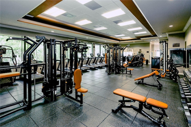 gym featuring crown molding and a tray ceiling