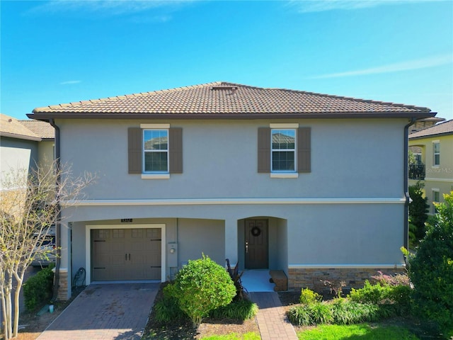 view of front of house with stone siding, a tiled roof, and stucco siding