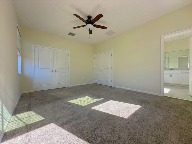 unfurnished bedroom with carpet flooring, visible vents, and baseboards