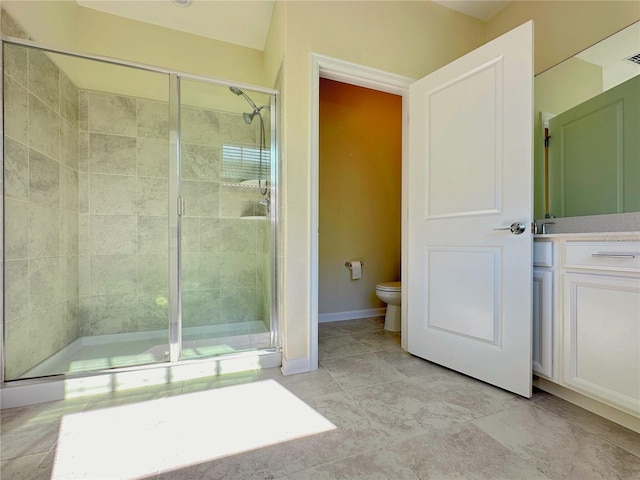 bathroom featuring toilet, visible vents, vanity, baseboards, and a stall shower