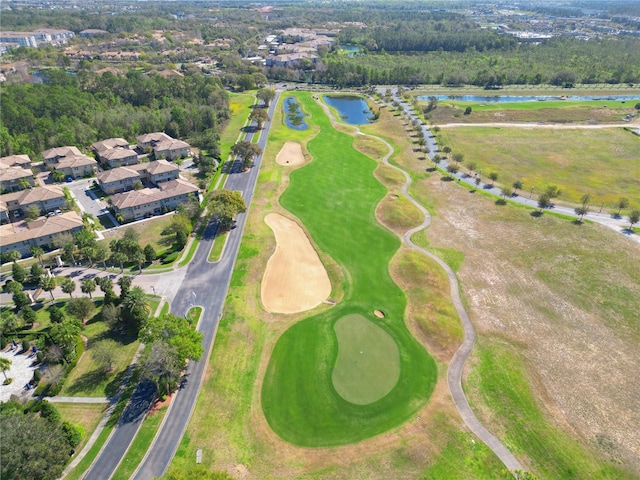 drone / aerial view with a water view and view of golf course