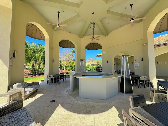 view of patio / terrace with ceiling fan, an outdoor hot tub, and outdoor dining space