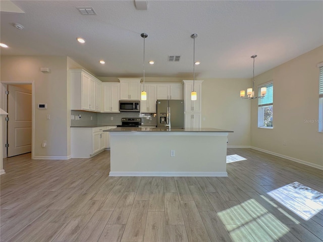 kitchen featuring appliances with stainless steel finishes, white cabinets, visible vents, and light wood finished floors