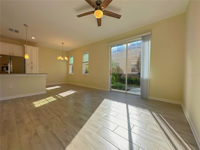 unfurnished living room with baseboards, visible vents, and light wood finished floors