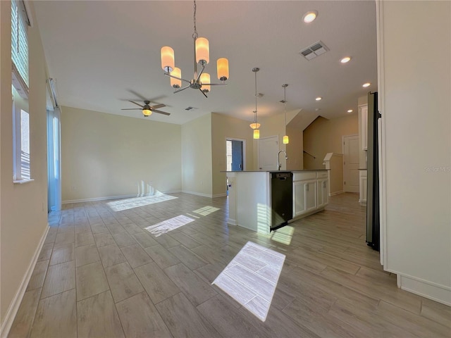 interior space with visible vents, wood tiled floor, open floor plan, white cabinets, and dishwasher