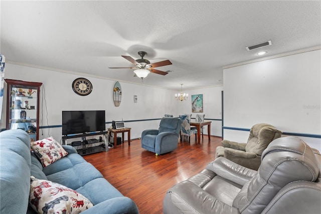 living room featuring ceiling fan with notable chandelier, wood-type flooring, and a textured ceiling