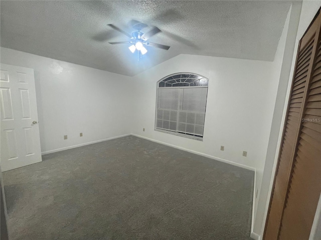 unfurnished bedroom featuring ceiling fan, vaulted ceiling, a textured ceiling, and dark colored carpet