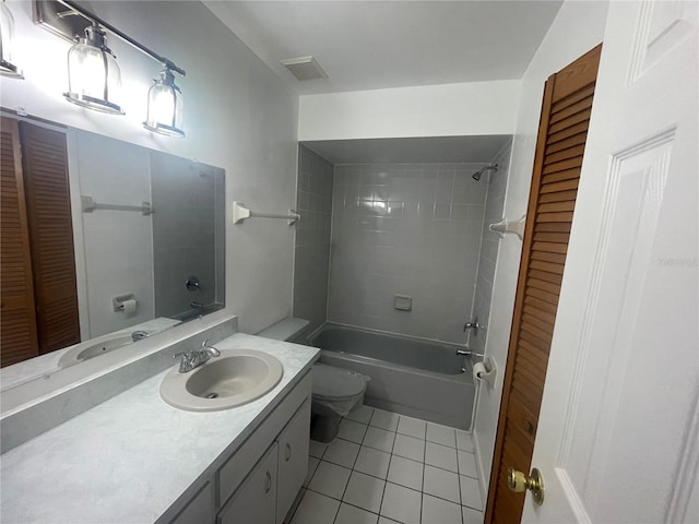 full bathroom with tile patterned flooring, vanity, tiled shower / bath combo, and toilet