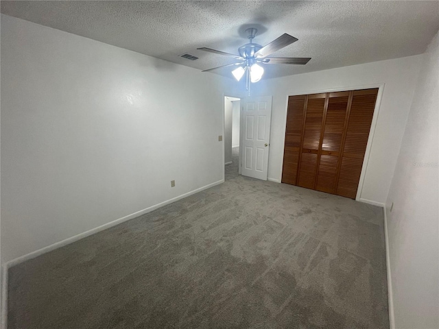 unfurnished bedroom with a textured ceiling, a closet, ceiling fan, and carpet