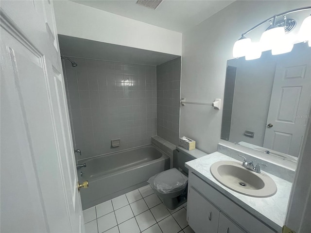 full bathroom with tile patterned flooring, tiled shower / bath, vanity, and toilet