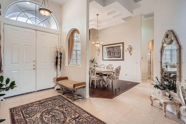 entrance foyer with a chandelier, a high ceiling, and light tile patterned floors